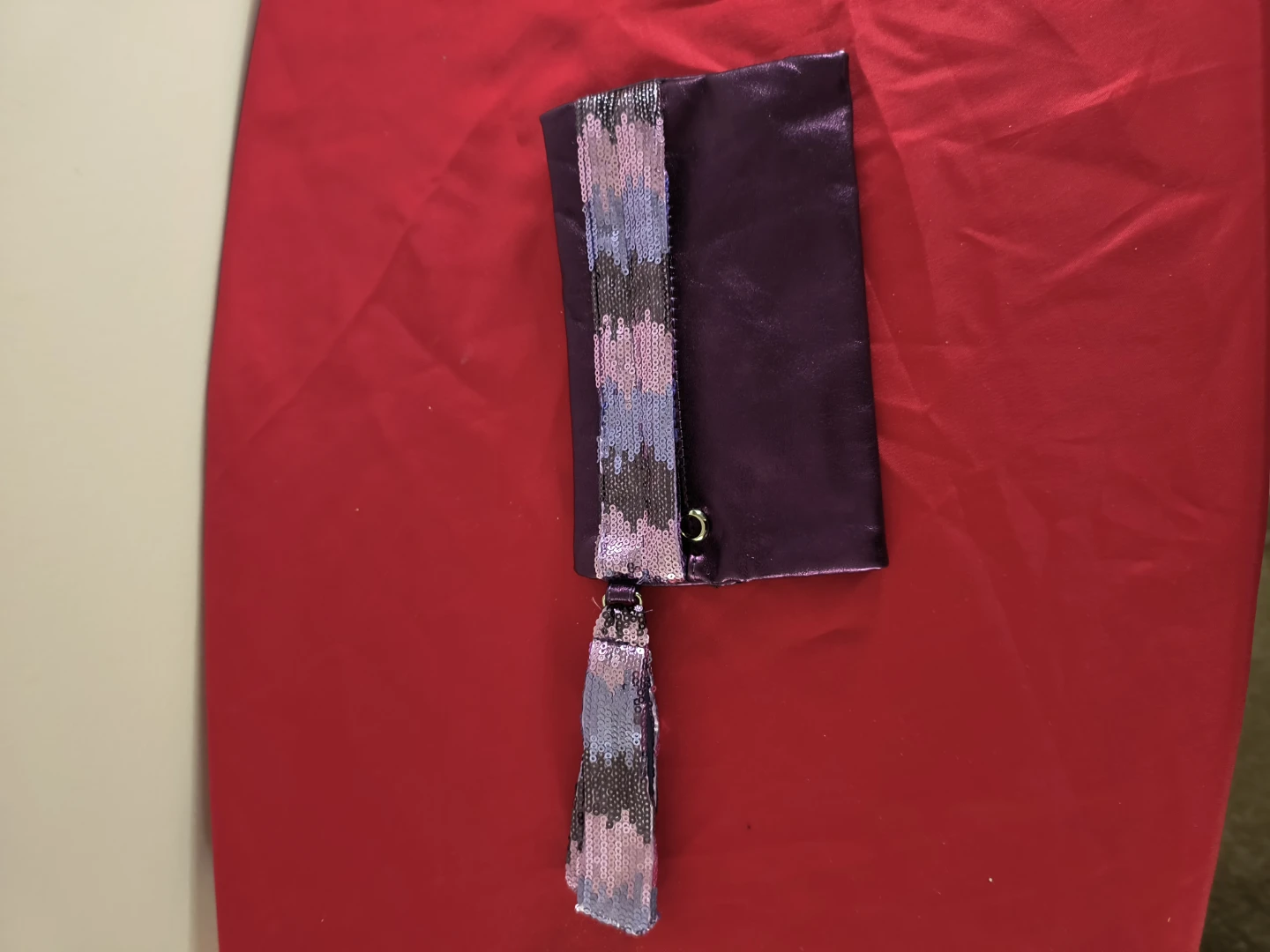 Purple clutch with sequin trim and tassel