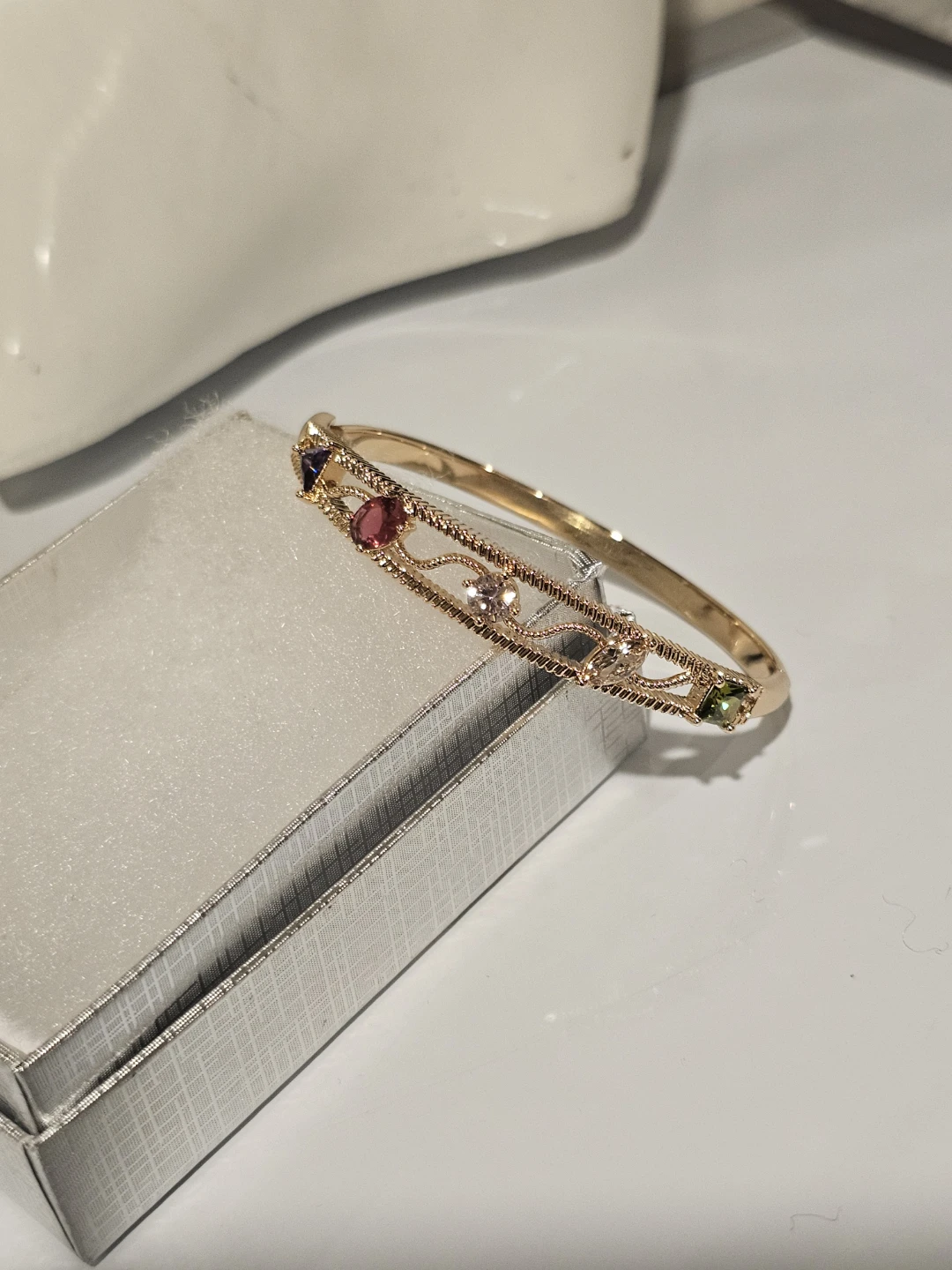 Gold tone bangle bracelet with colourful stones