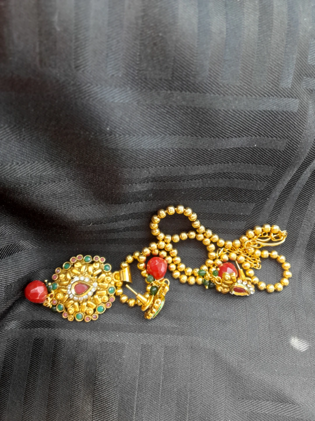 Faux Gold-tone pendant with red and green stones