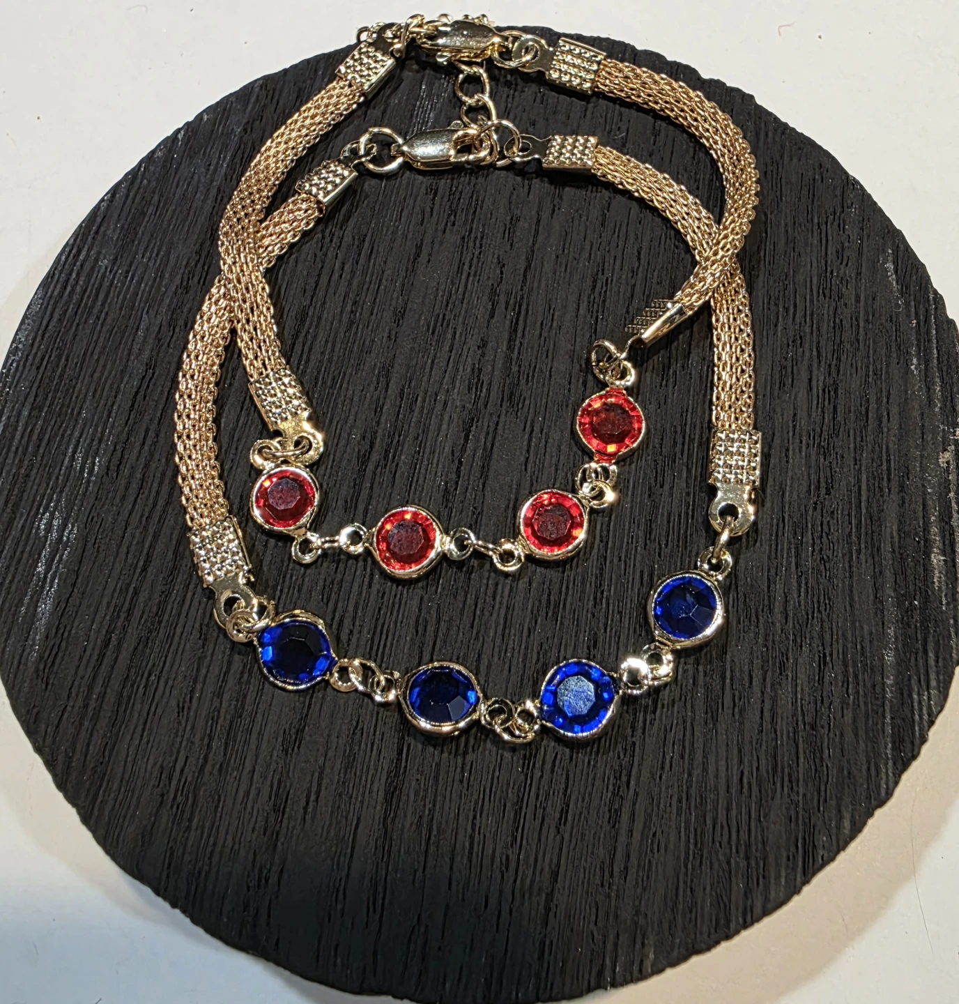 2 Gold tone link chain bracelets with red and blue gems