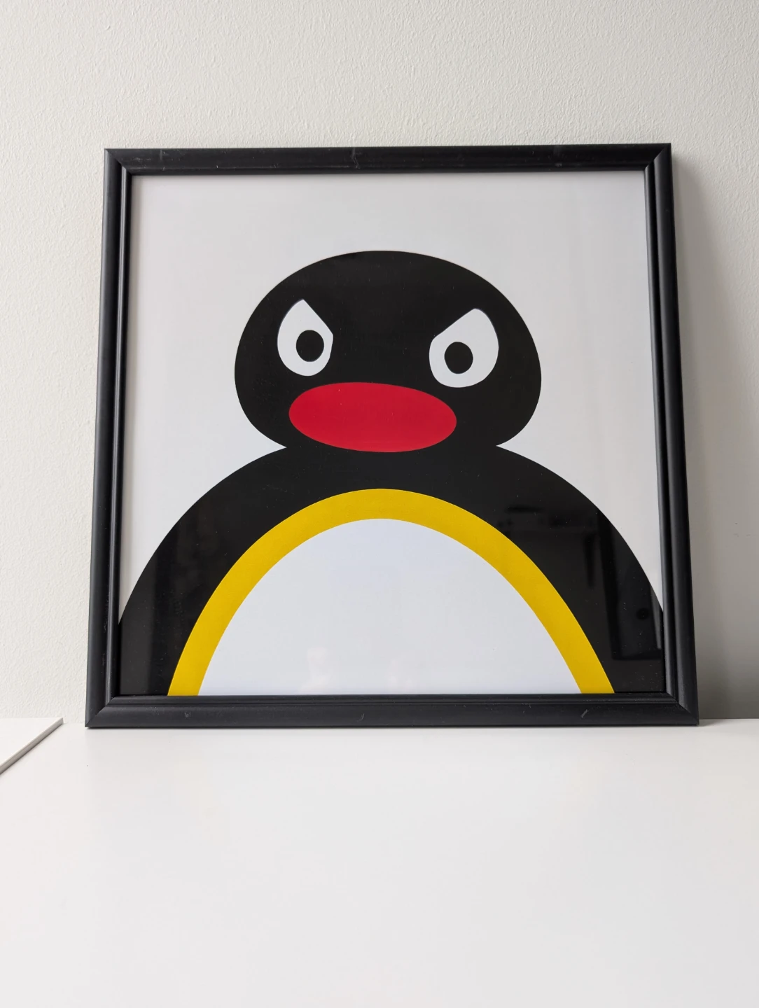 Framed Pingu print in black frame 31x31cm intense stare