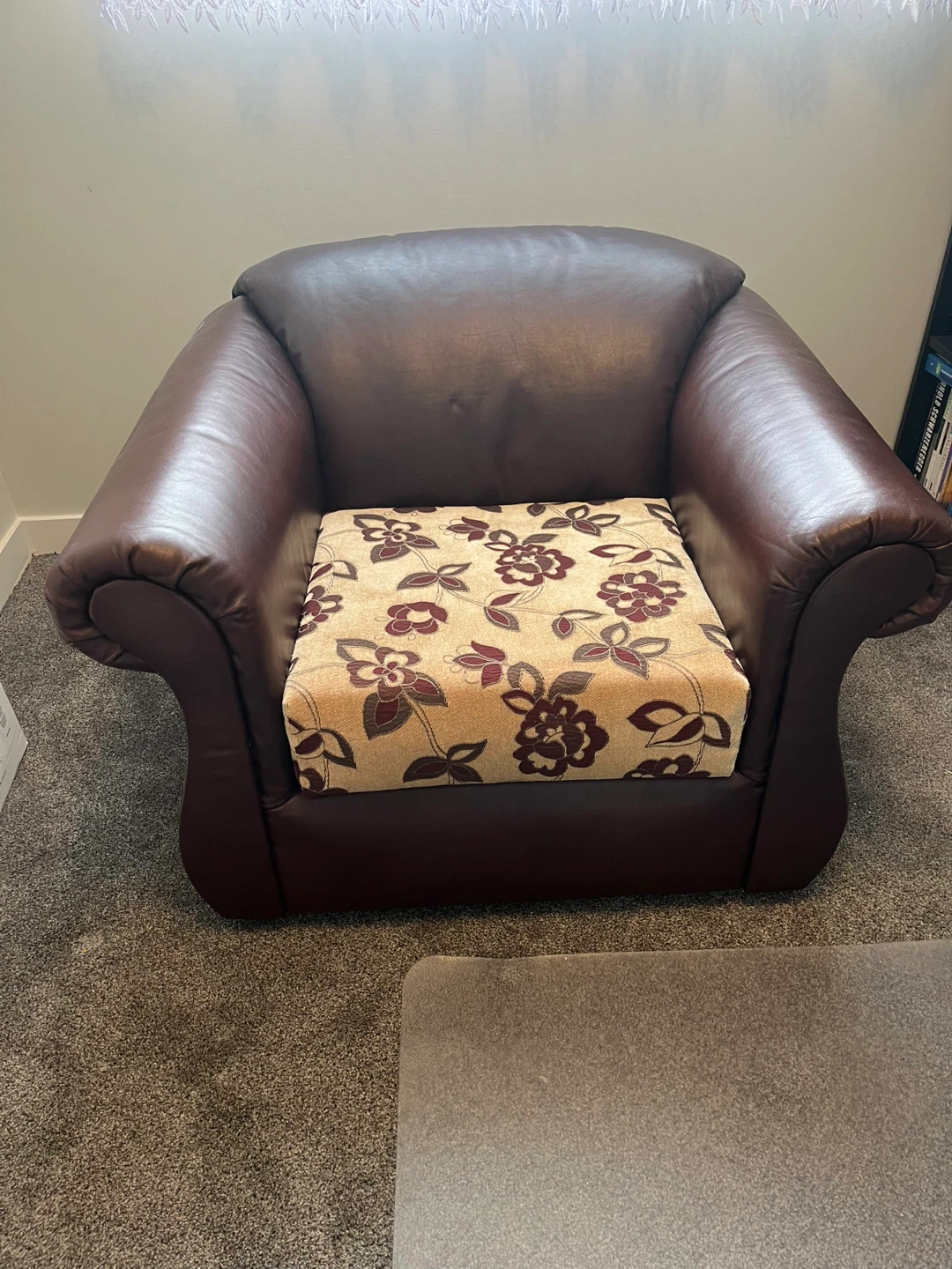 Brown leather armchair with floral cushion
