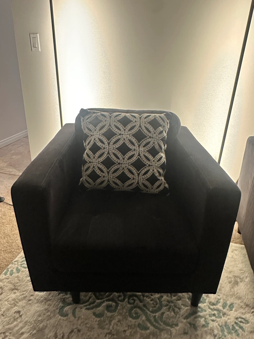 Black accent chair with decorative pillow