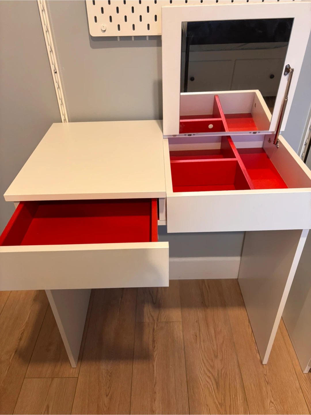 White vanity table with red interior drawers and mirror