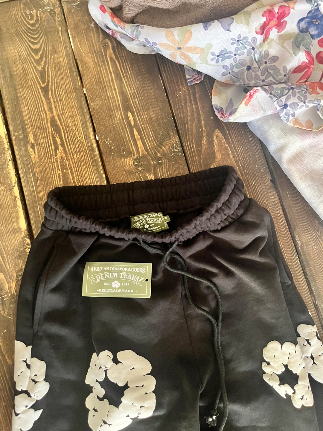 Denim Tears Black Sweatpants with White Floral Print