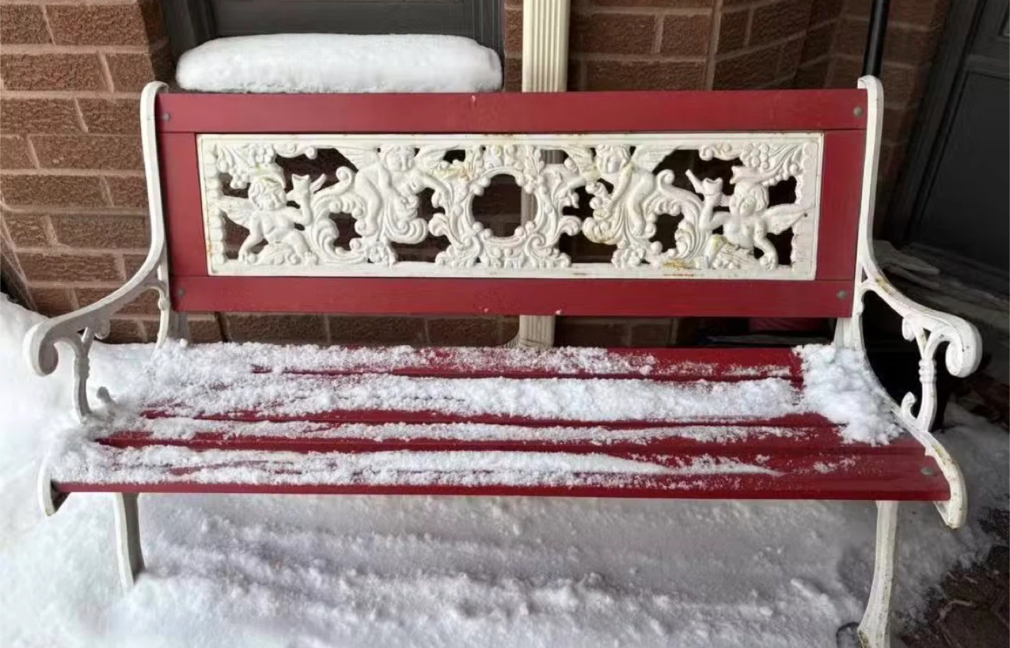Red and White Cast Iron Bench with Cherub Detailing