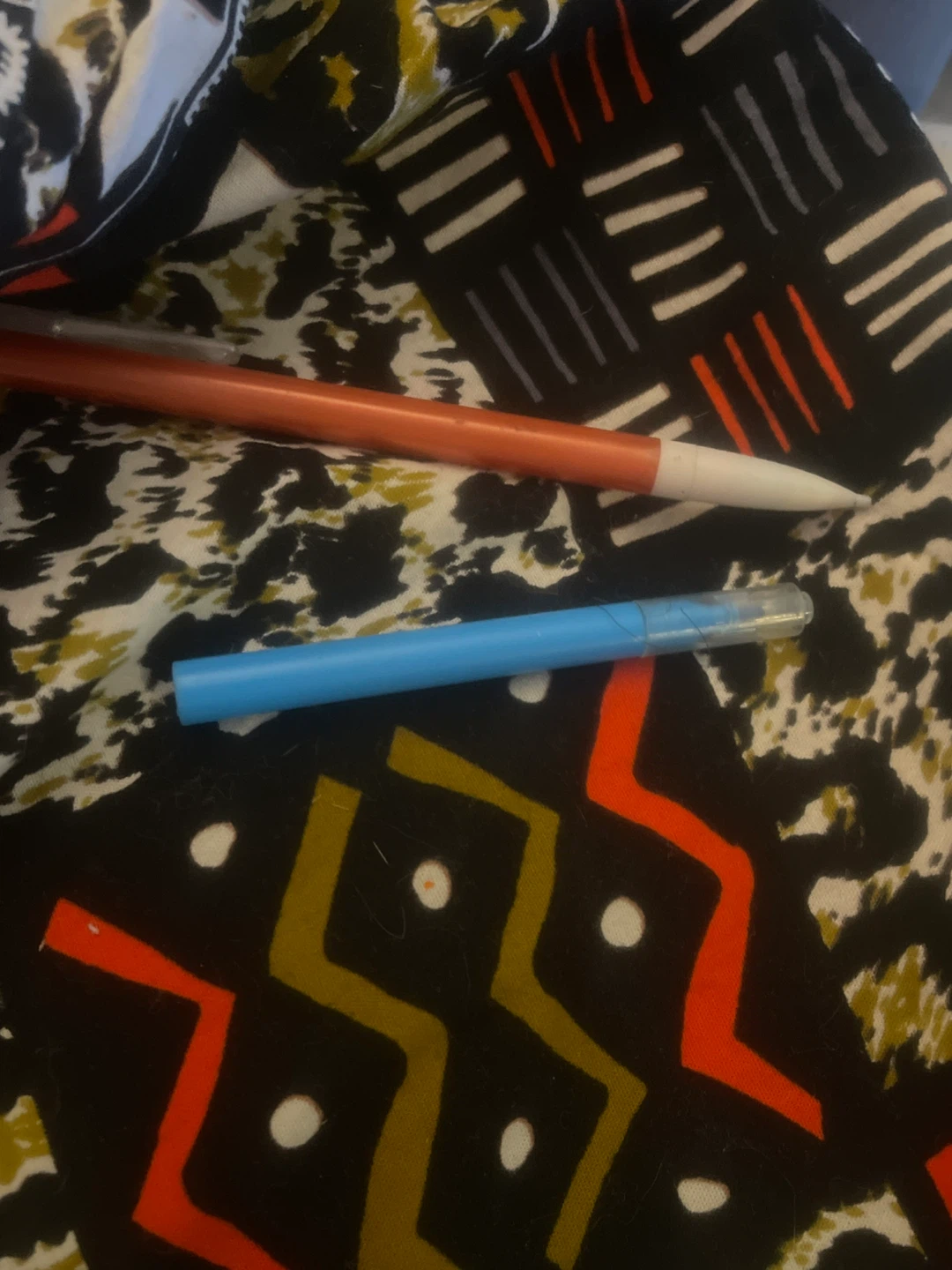 Orange mechanical pencil and blue pen