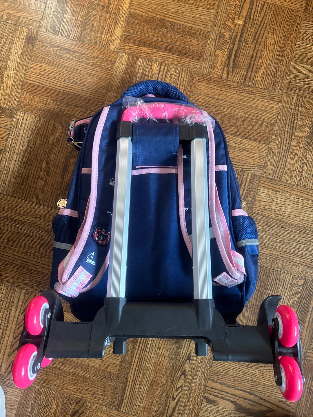 Blue rolling backpack with pink accents - photo 3