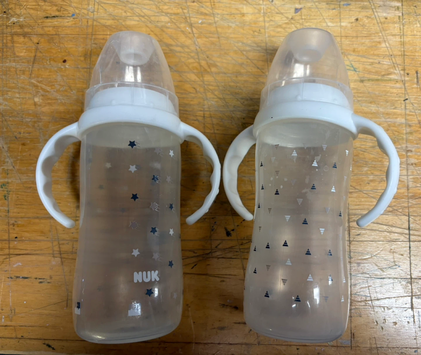 Assortment of baby bottles, plate, spoons, cactus toy