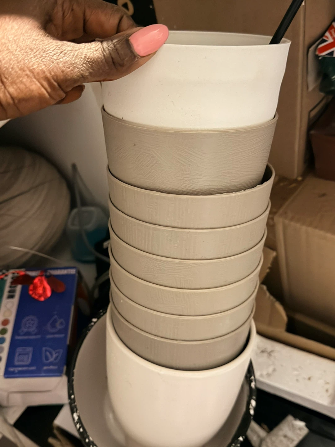 Stack of 9 white and beige plant pots