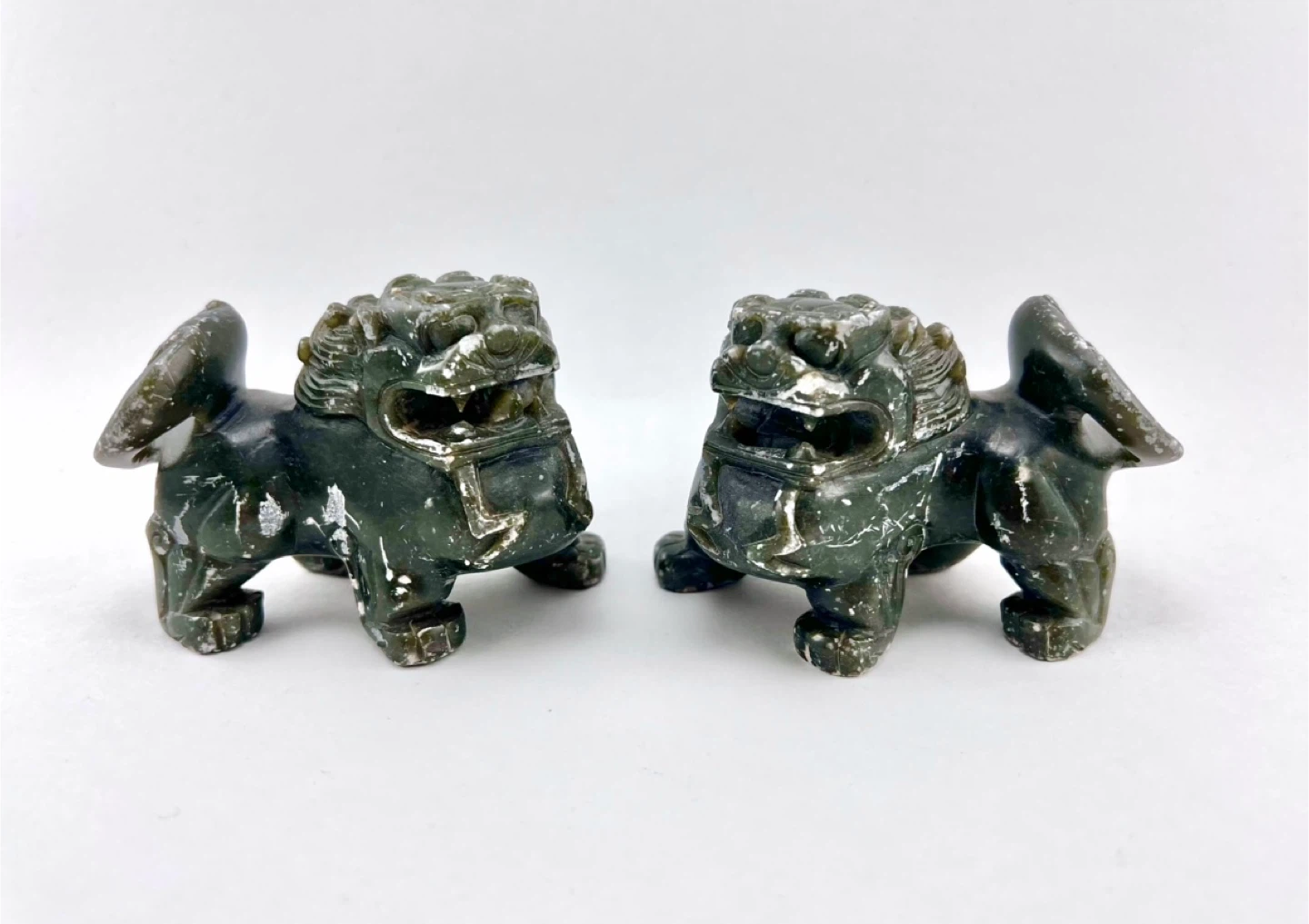 Pair of small dark green soapstone carved food dog figurines