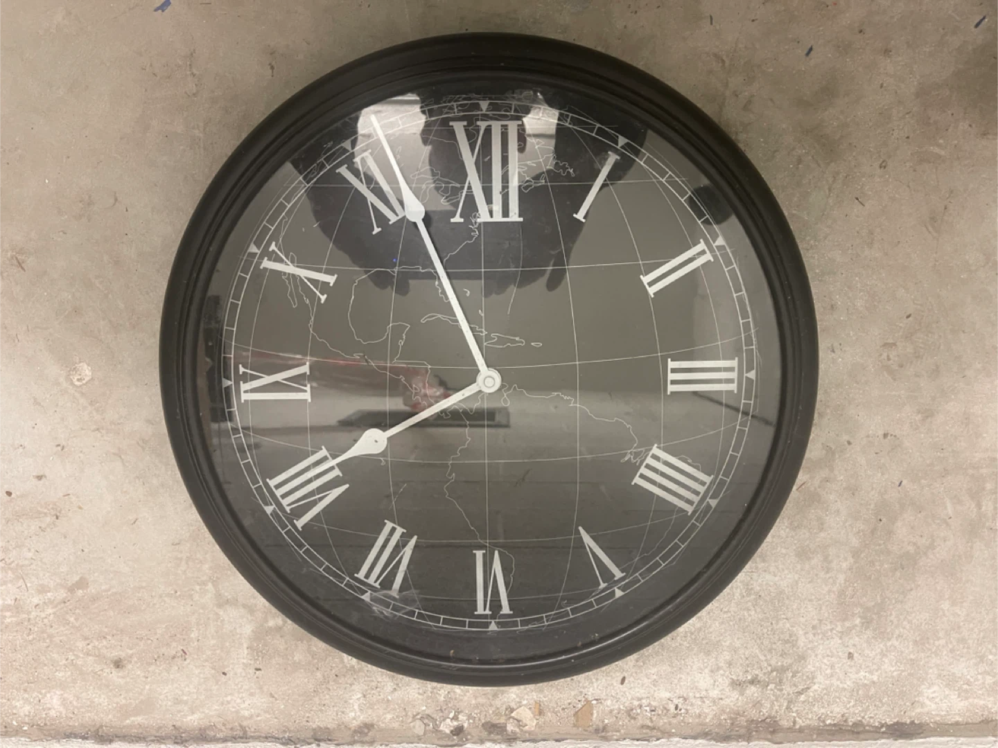 Black Wall Clock with Roman Numerals and World Map Design