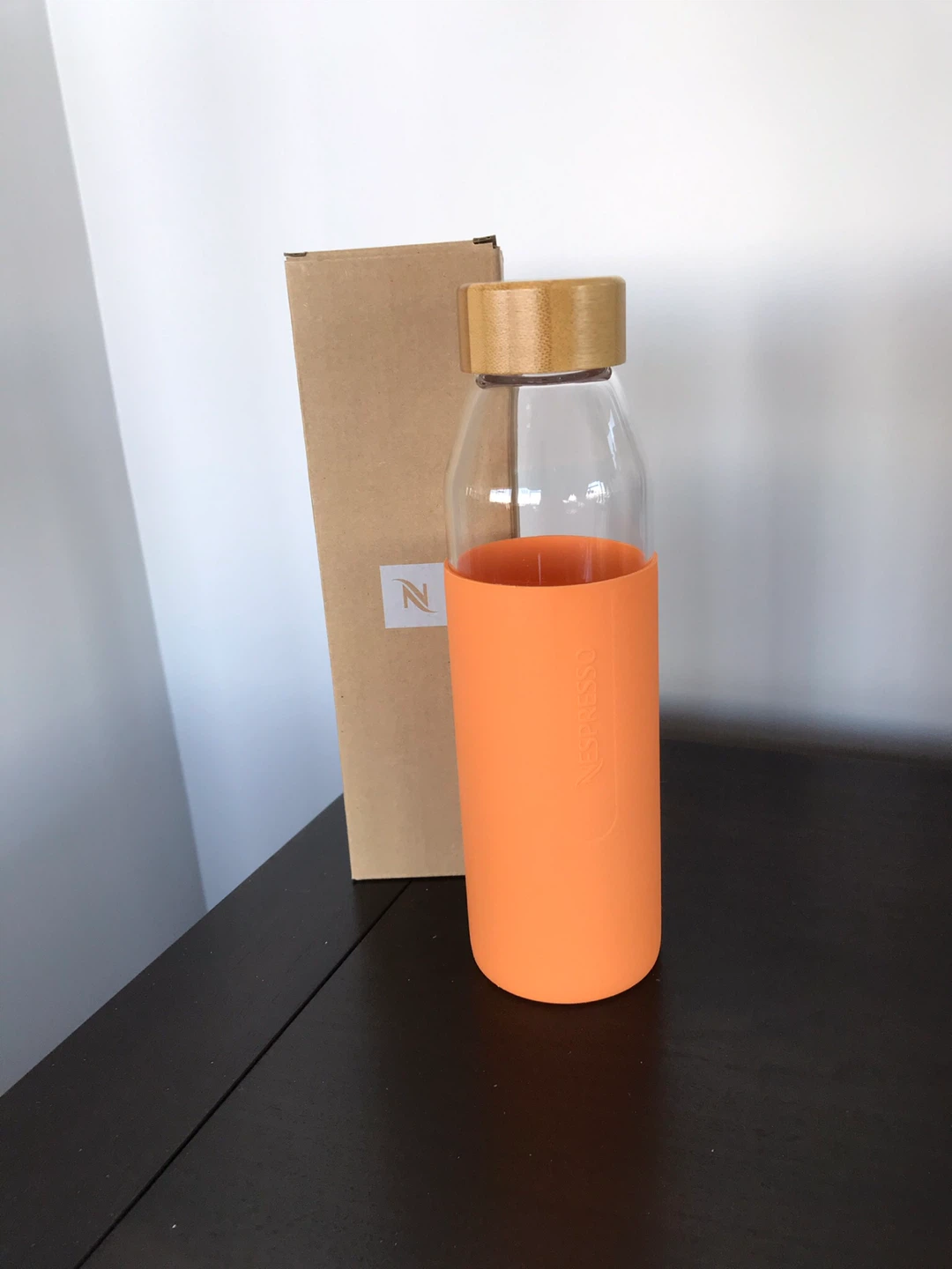 Nespresso Glass Water Bottle with Orange Sleeve and Bamboo Lid
