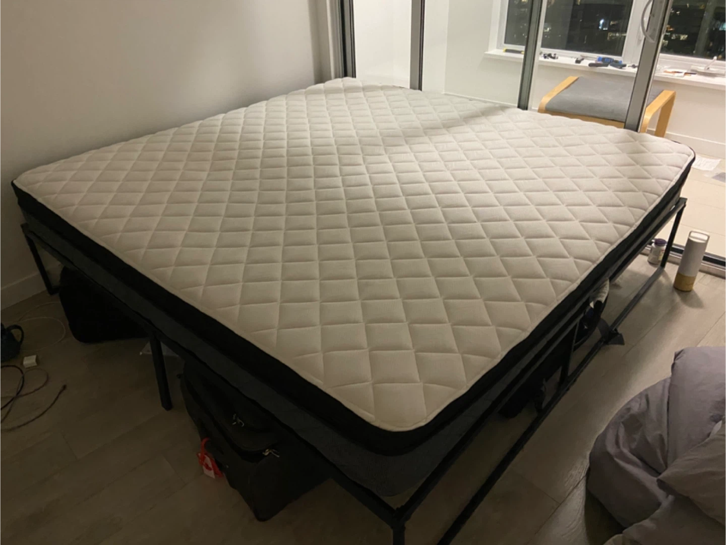 King size mattress with metal bed frame and bedsheets