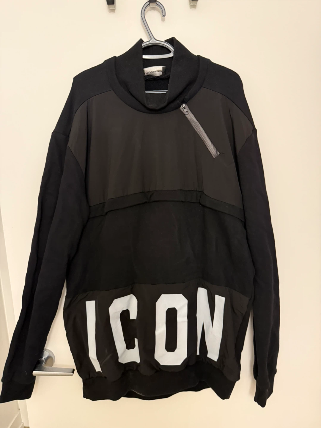 Black streetwear sweatshirt with bold ICON graphic and zip.