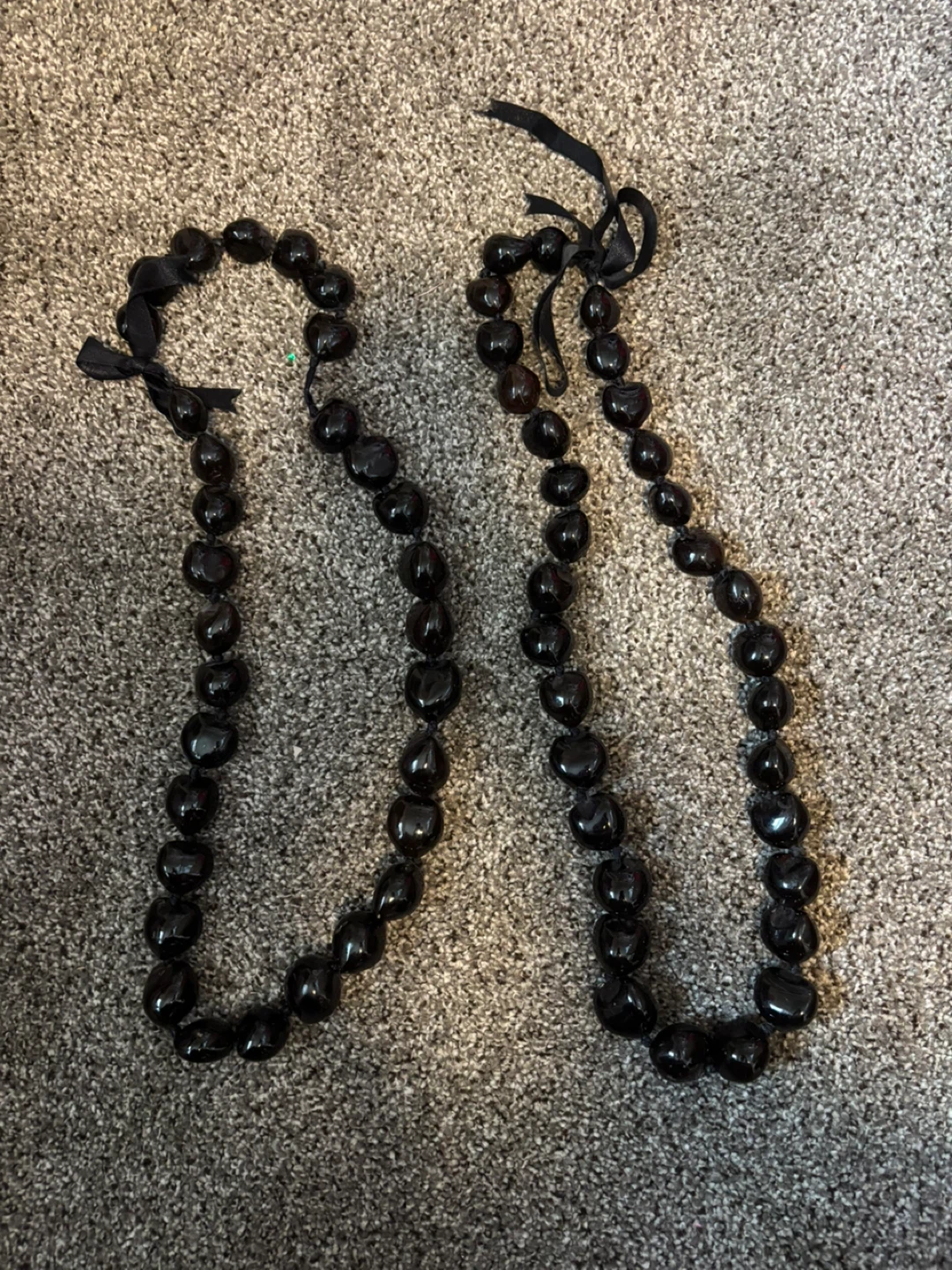 Two black Kukui nut leis