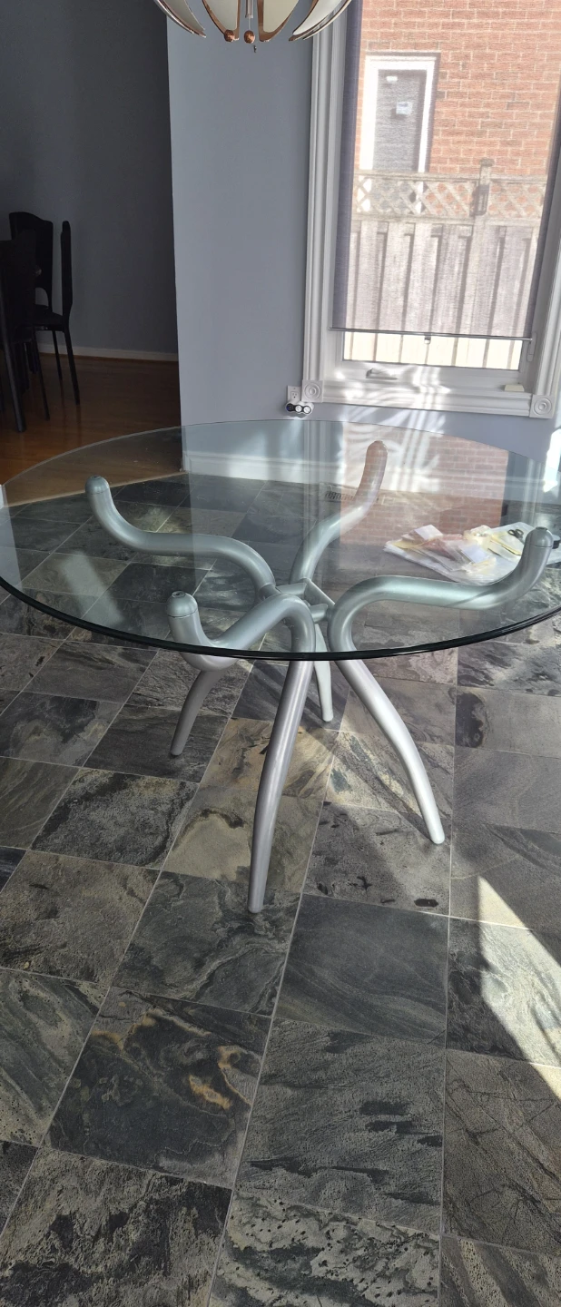 Glass top dining table with unique metal base