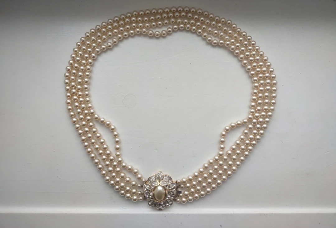 Multi-strand faux pearl necklace with rhinestone flower