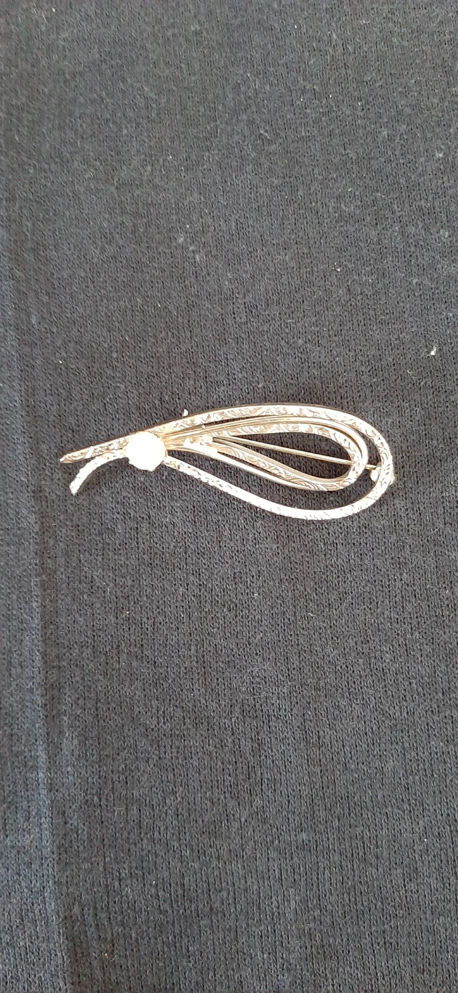 silver tone brooch with intricate scroll design & pearl.