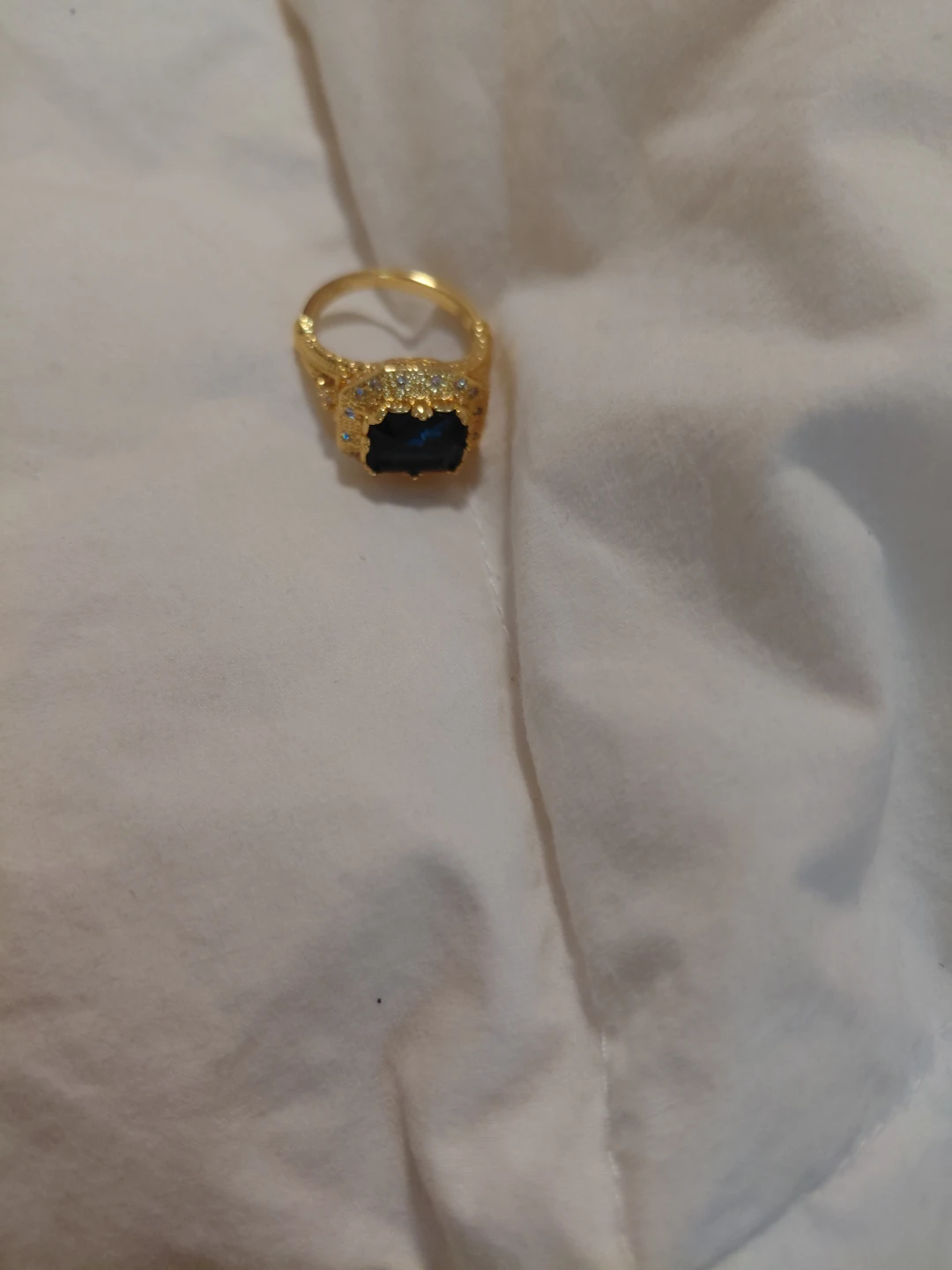 Gold-toned statement ring with dark blue stone