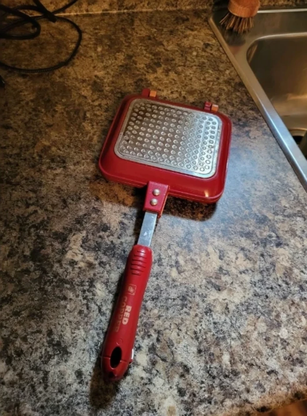 Red stovetop sandwich maker and small cast iron pan