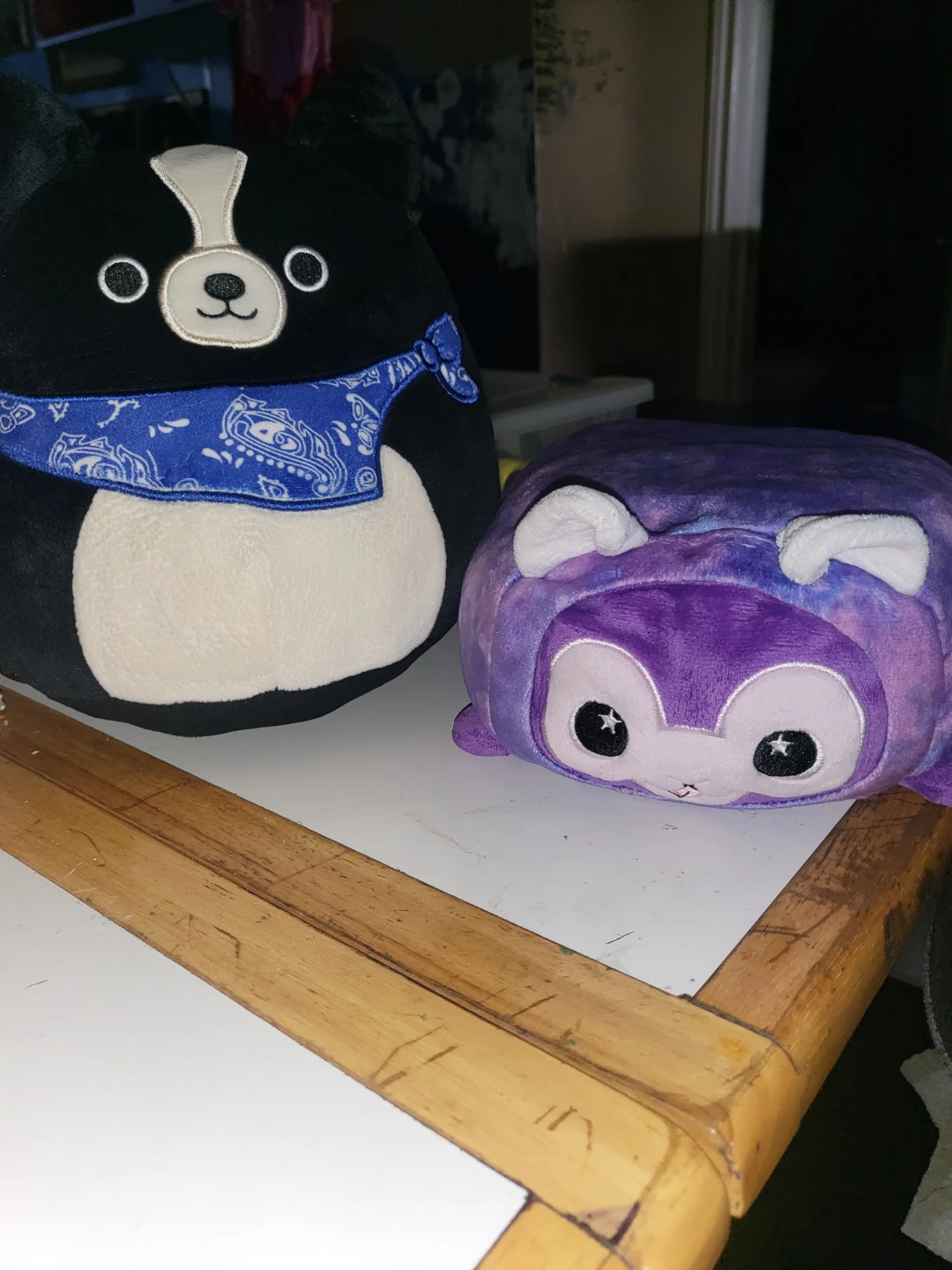 Two plush toys: Dog with bandana and purple creature