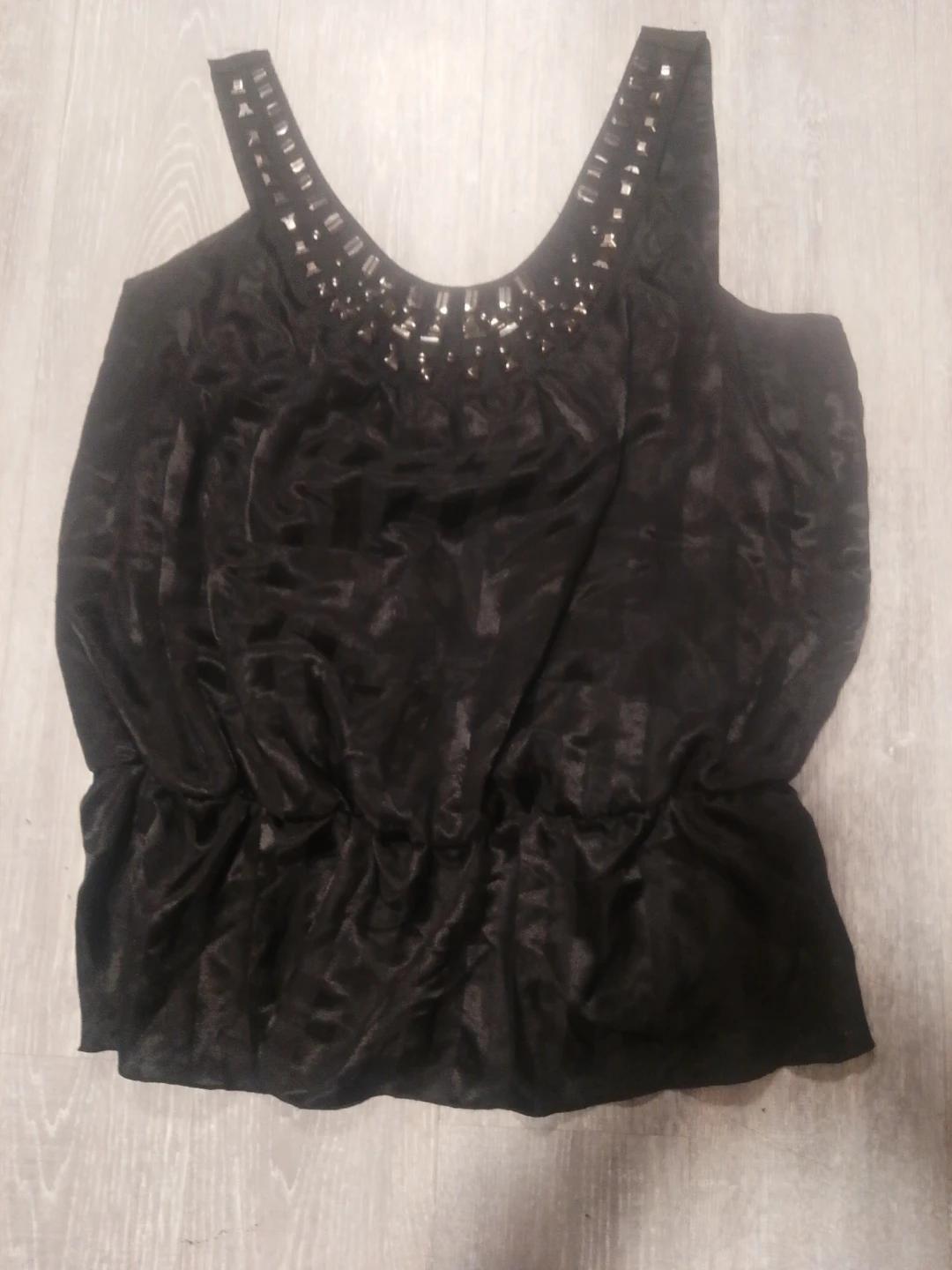 Black sleeveless top with embellished neckline