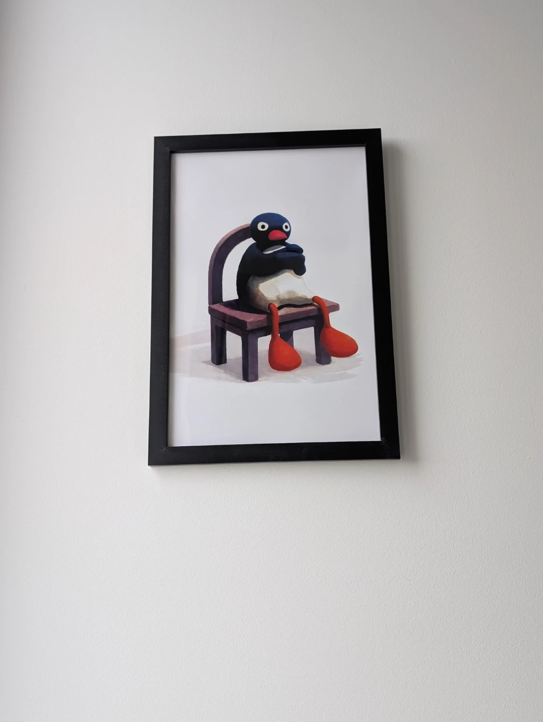 Framed 35x50cm upset Pingu sitting on a chair print