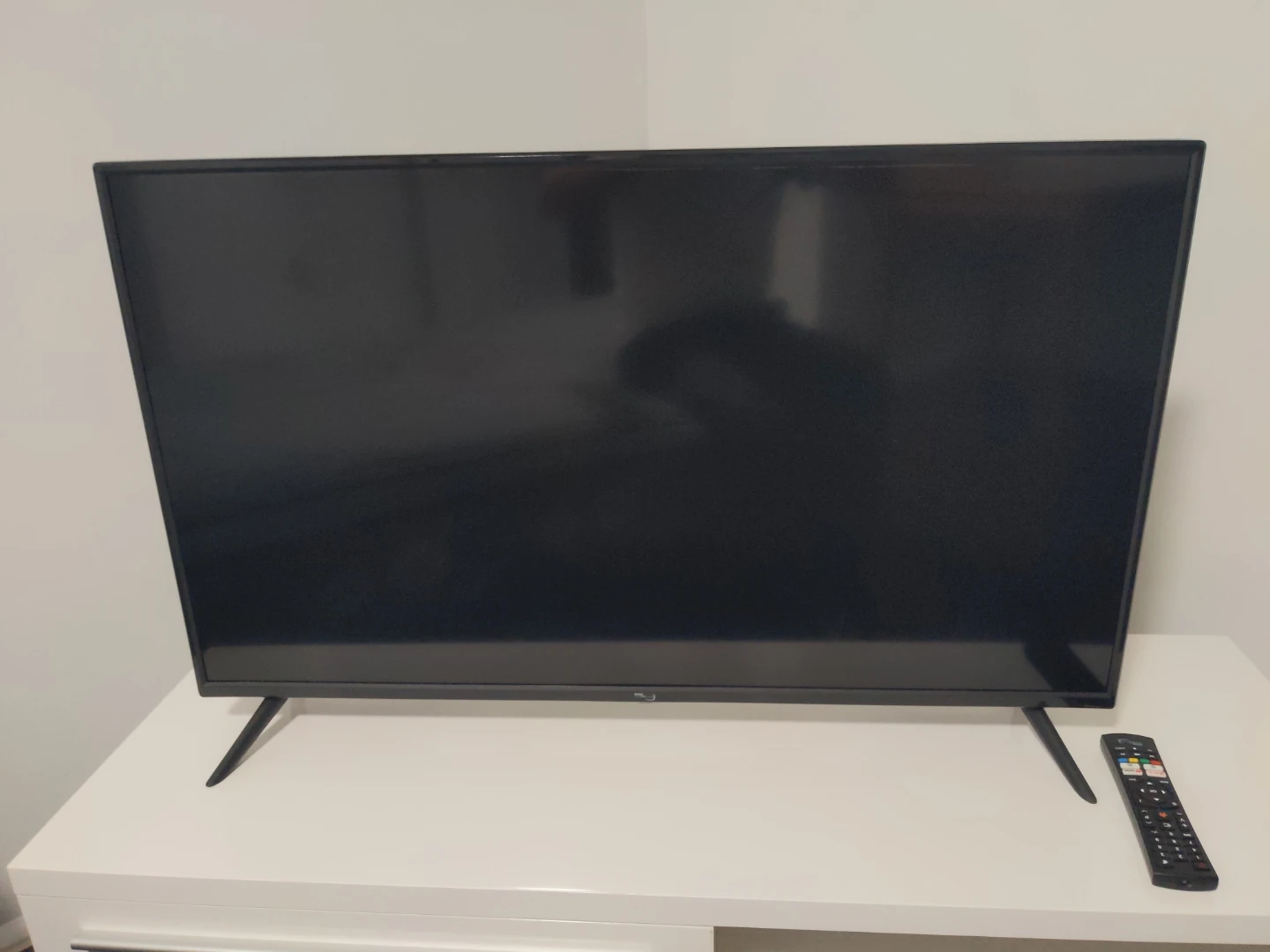 Black flat-screen smart TV with remote