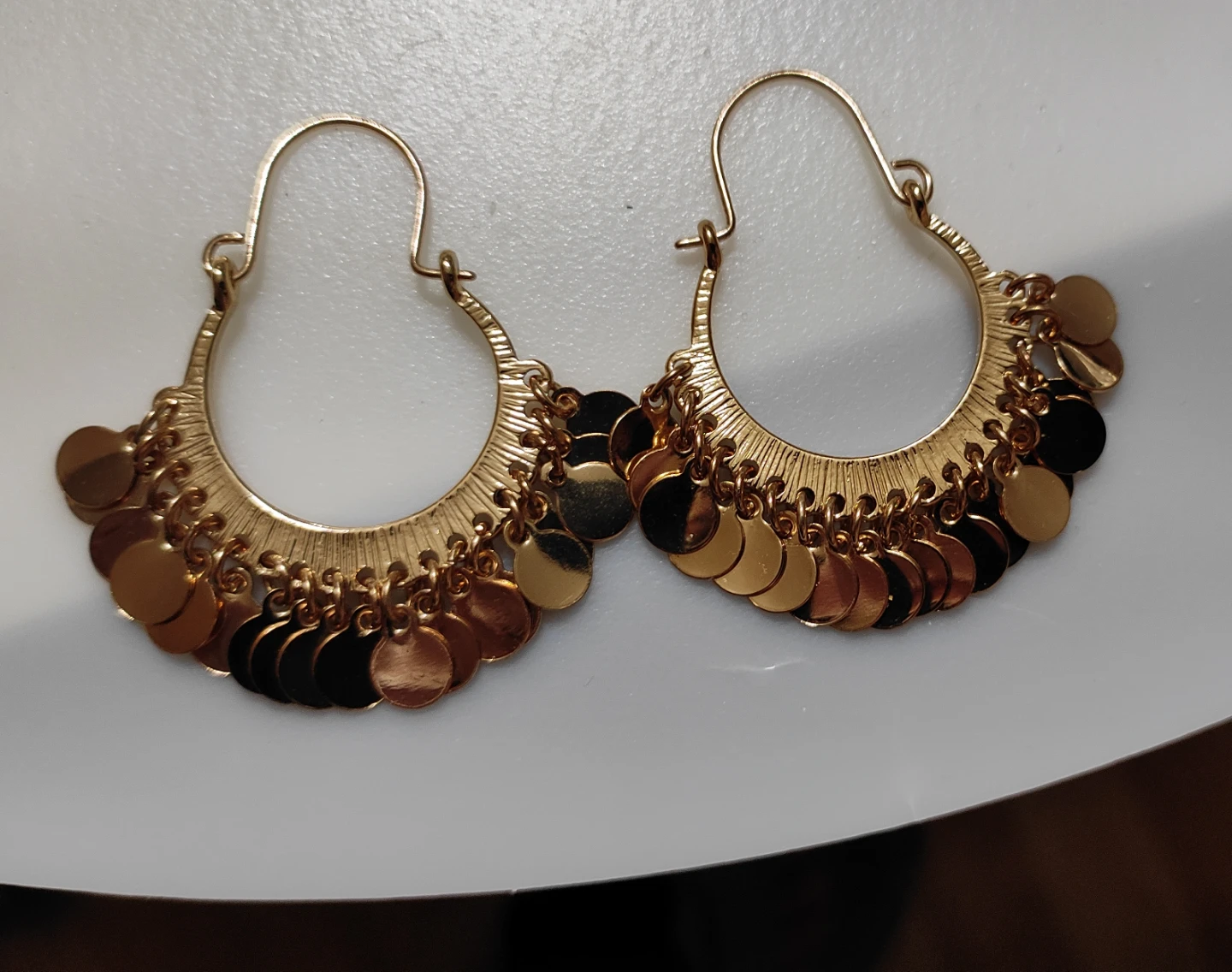 Gold tone hoop earrings with coin charms