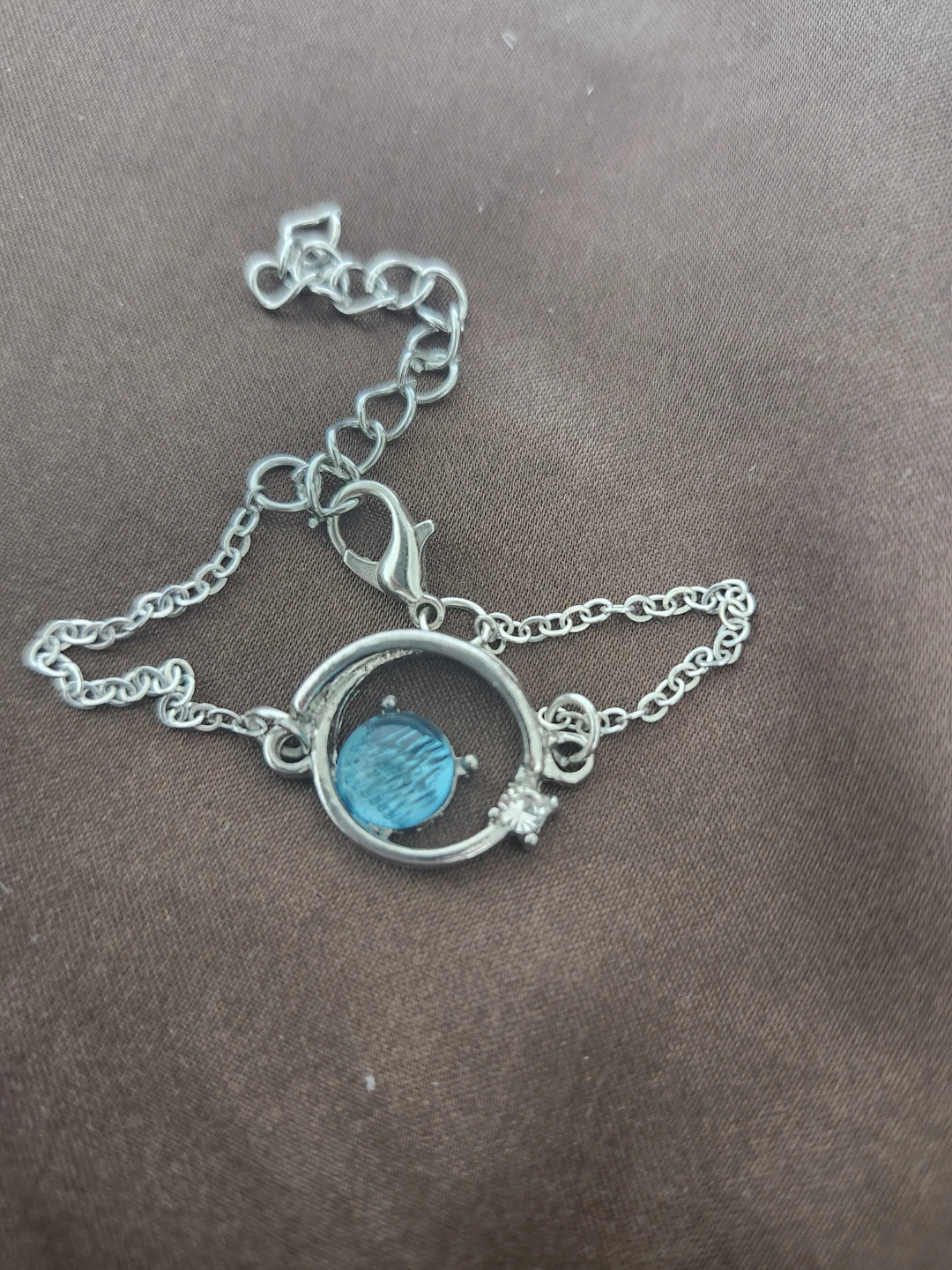 Silver-tone bracelet with blue circular charm