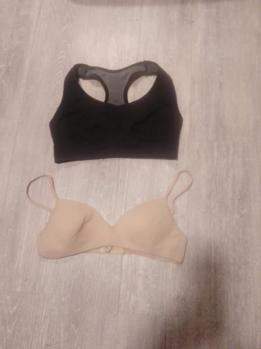 Two bras: black sports bra and nude wireless bra