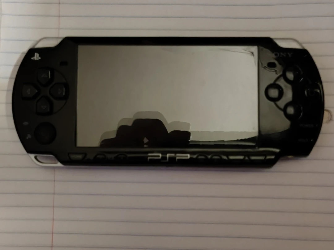 PSP 2001 IN MINT CONDITION WITH 7 GAMES AND 14 MOVIES