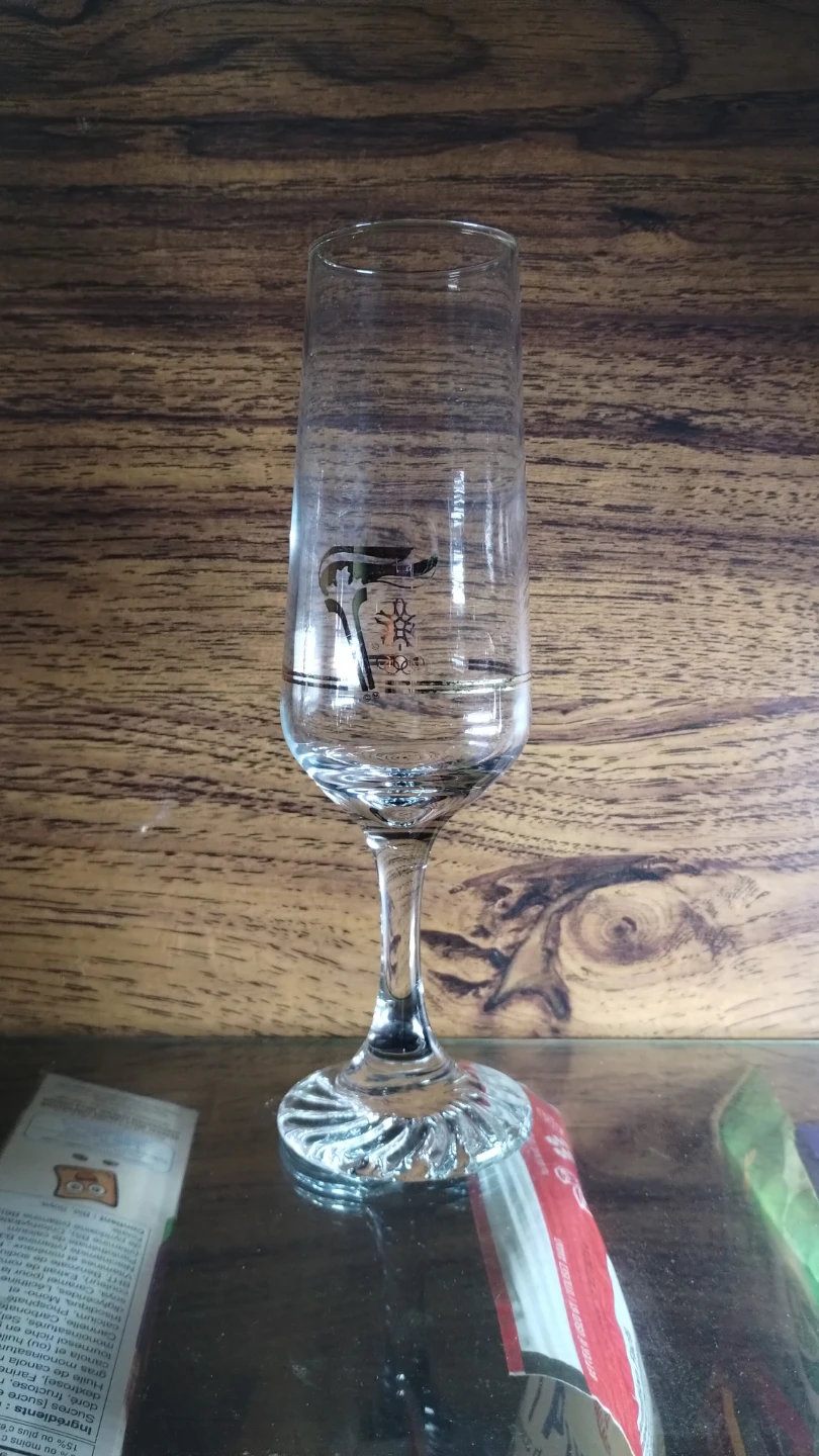Tall Olympic branded drinking glass