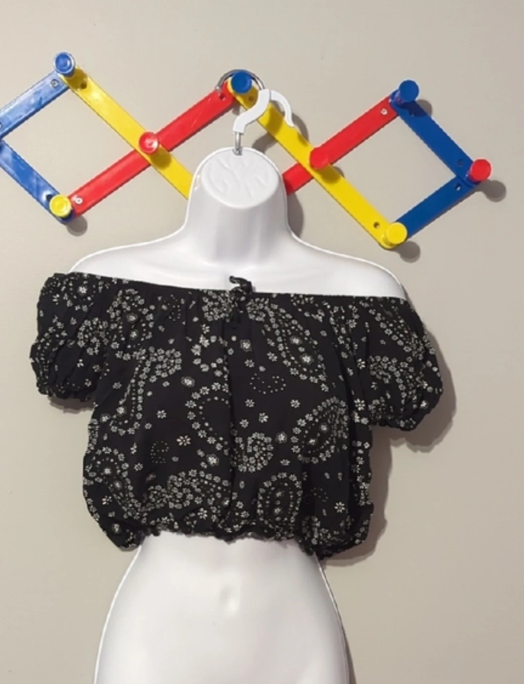 Black off-the-shoulder crop top with white floral print