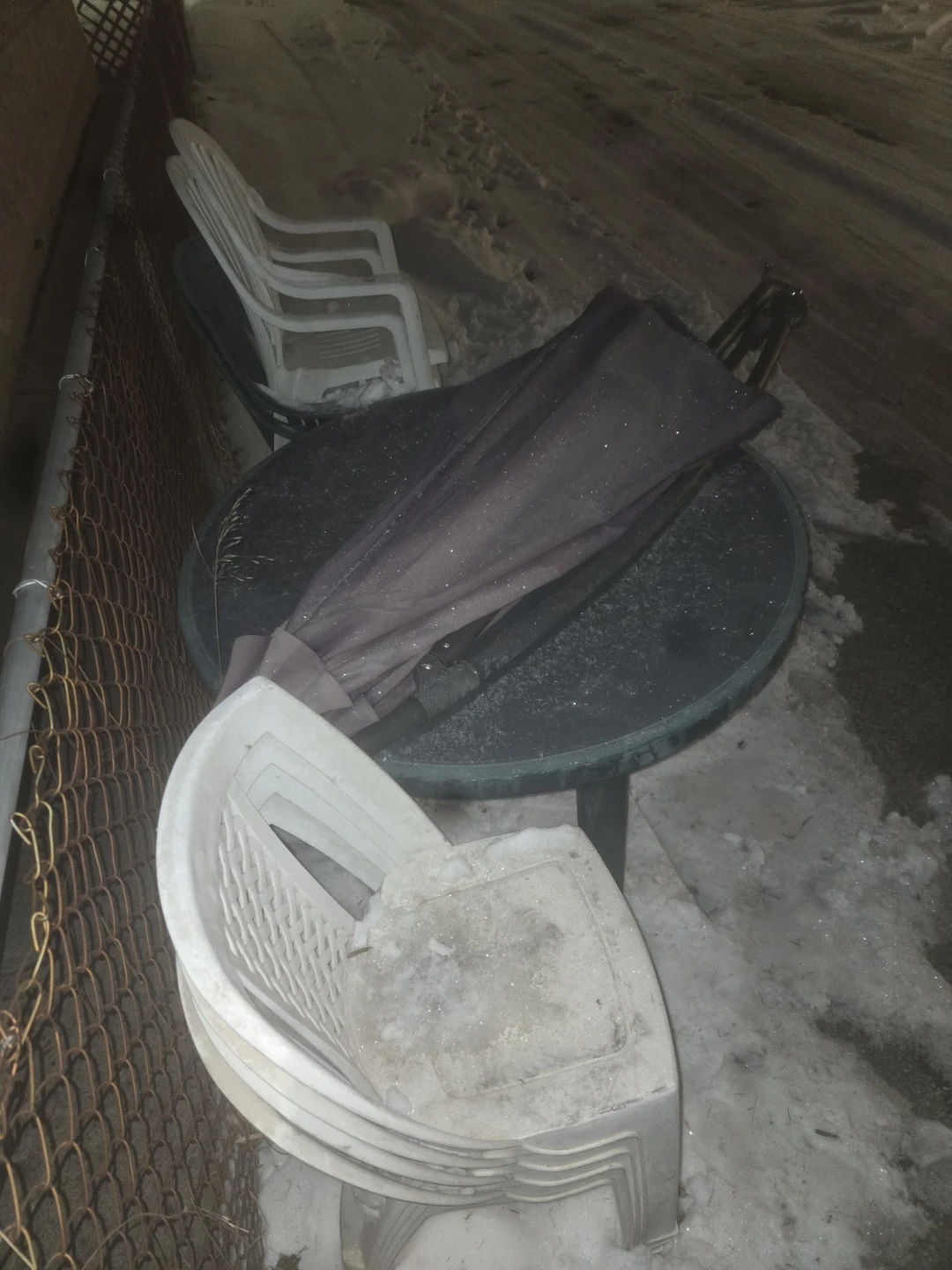 Stack of White Plastic Patio Chairs and Table