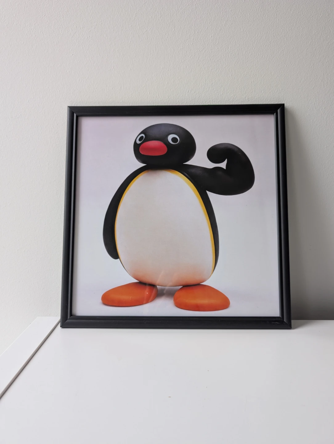Framed Pingu flexing Print in black frame, strong penguin