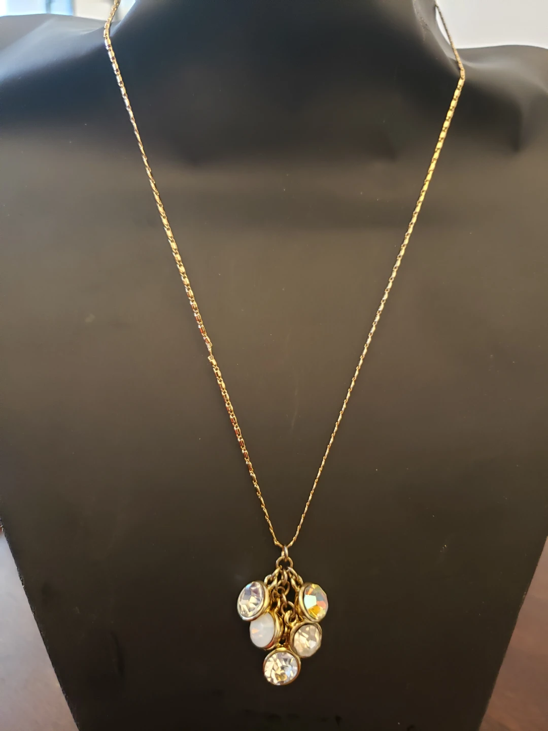 Gold tone pendant necklace with clear and iridescent charms