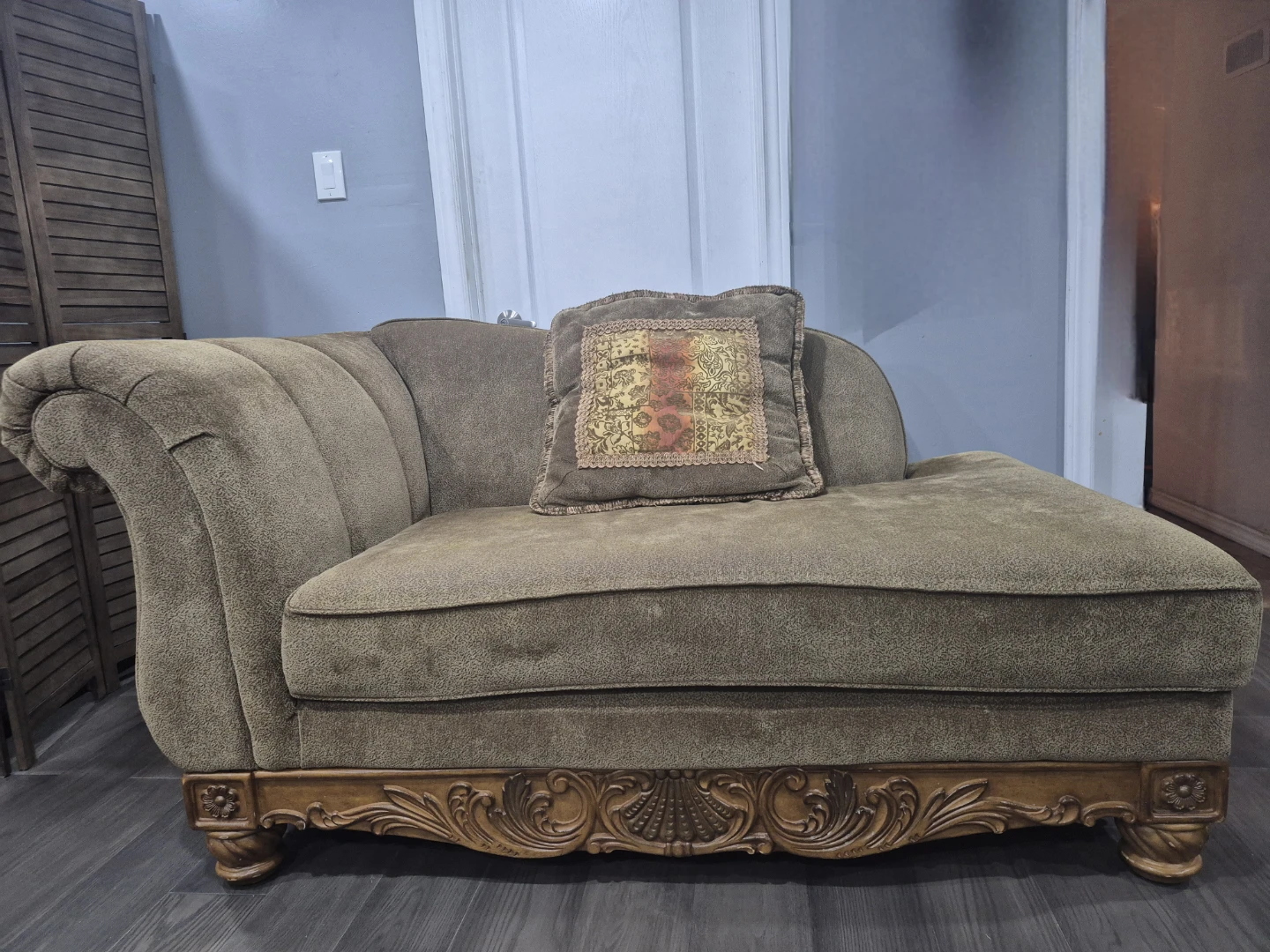 Brown upholstered chaise lounge with decorative wood trim