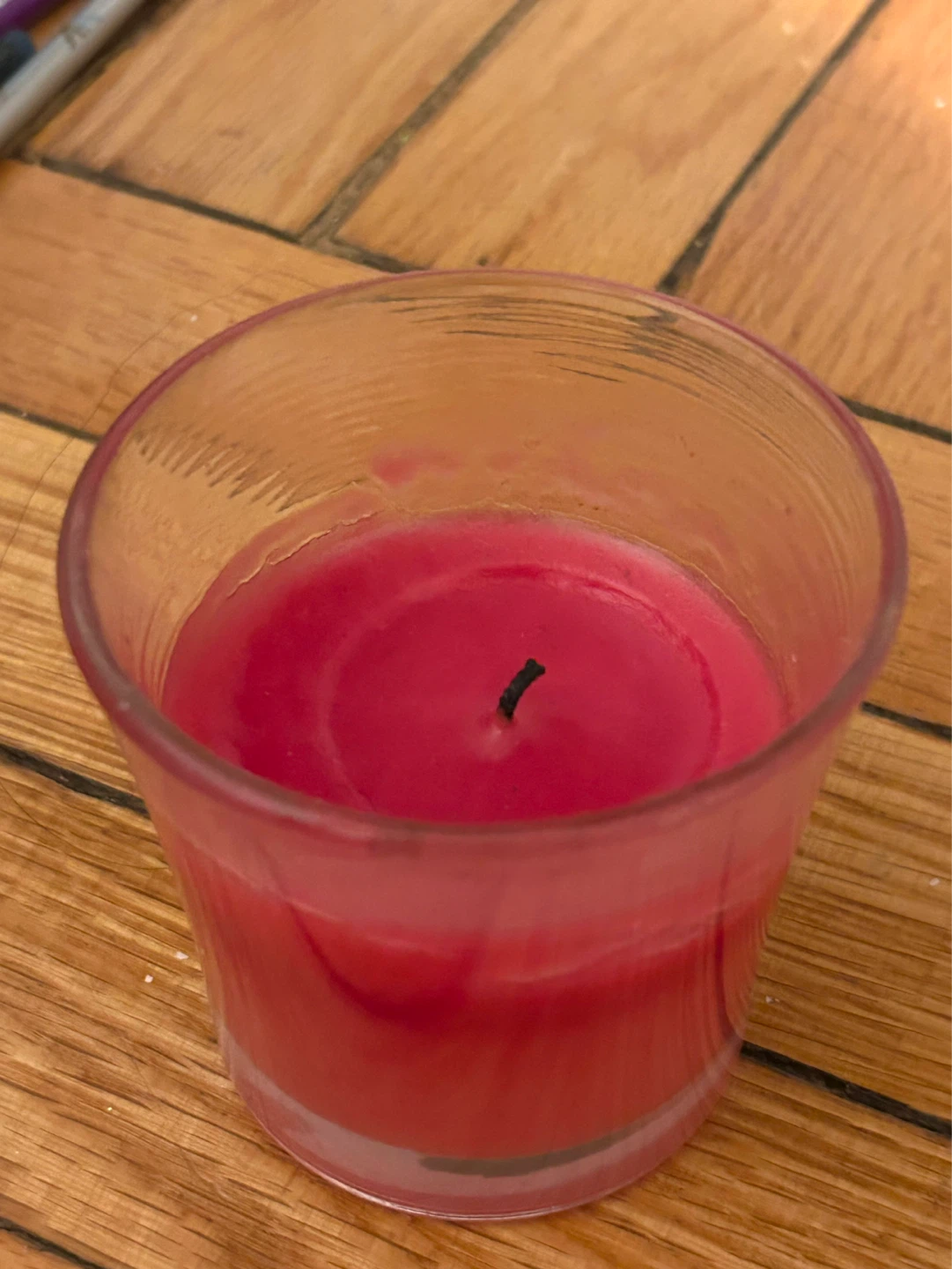 Pink scented candle in glass holder
