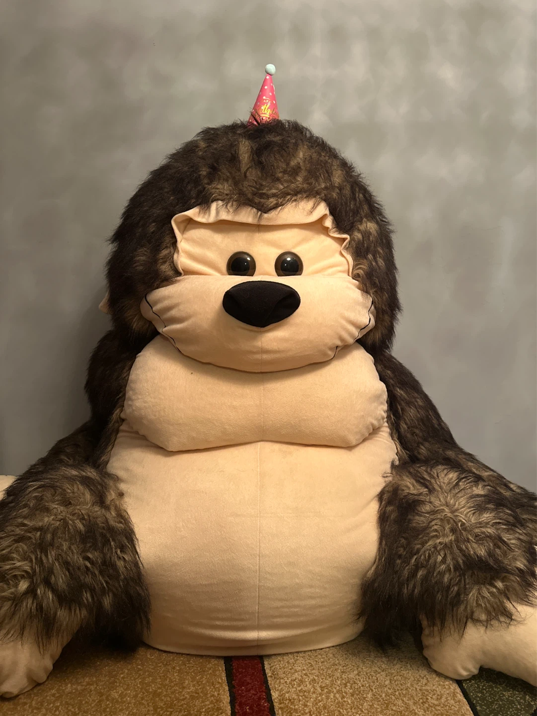 Large plush ape toy with birthday hat