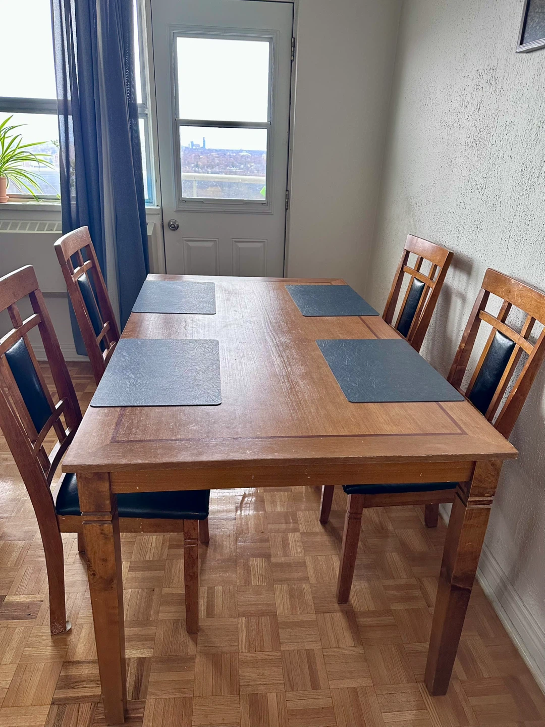 Wooden dining table with four chairs.