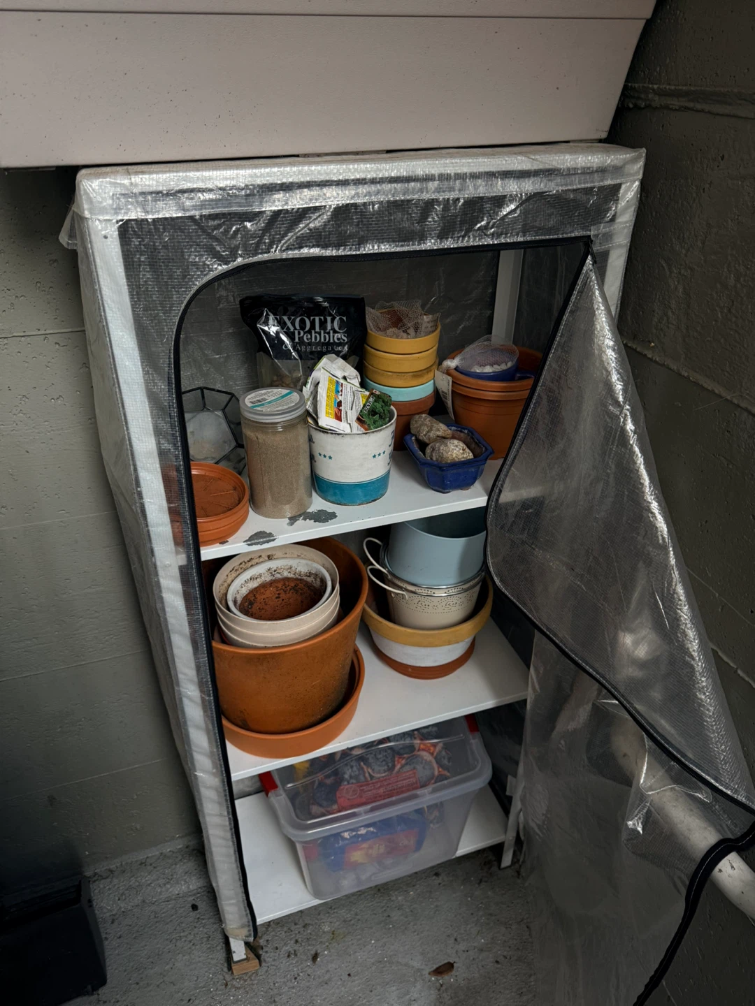 Shelving unit with assorted plant pots and garden supplies