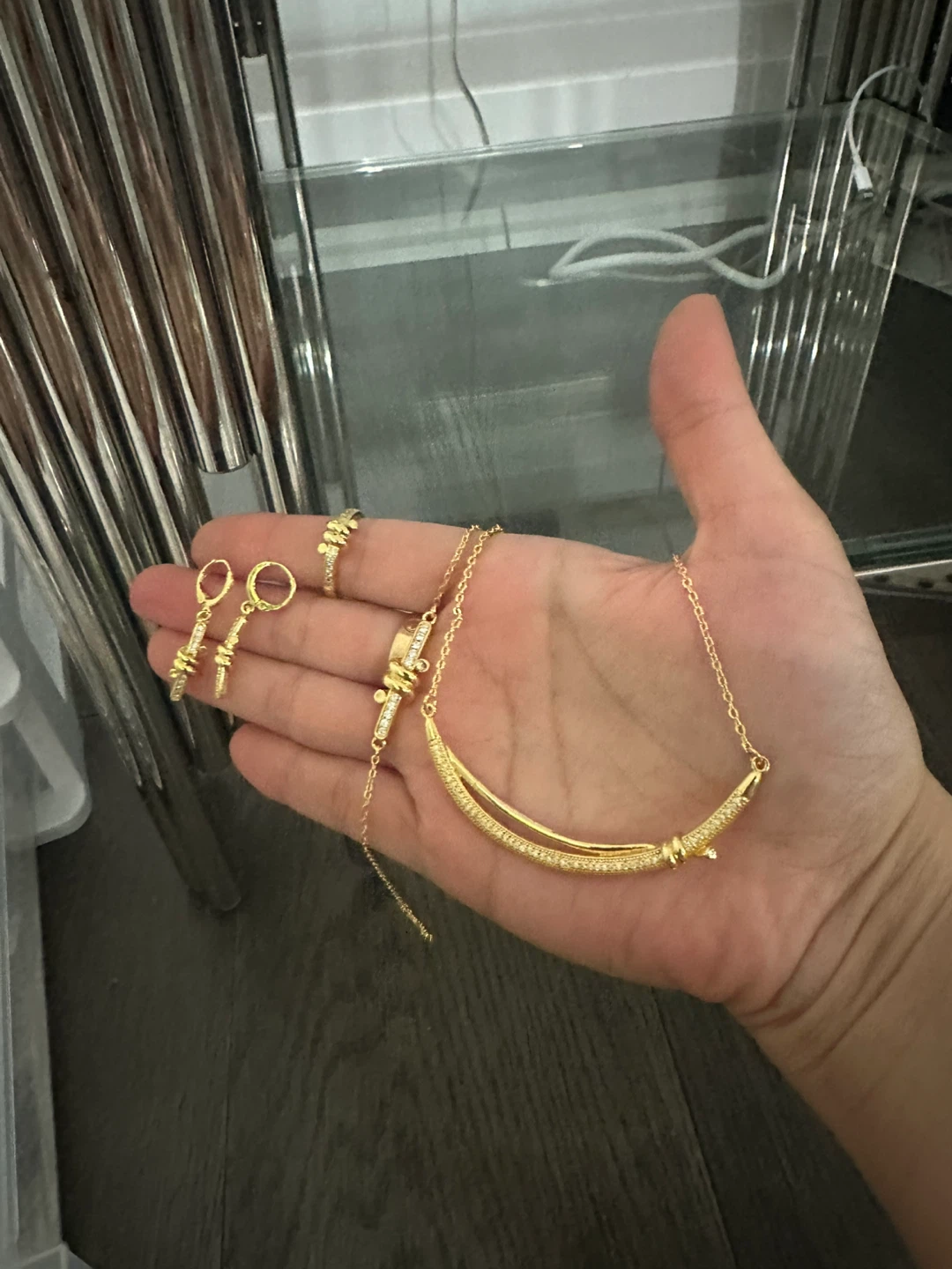 Gold coloured jewellery set with necklace, earrings, and ring