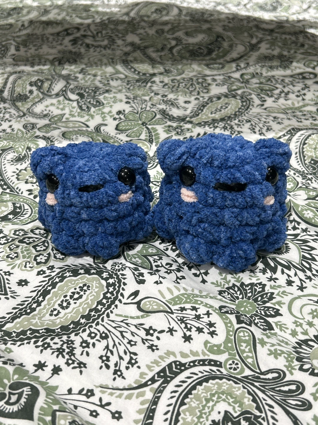 Two blueberry crochet frogs
