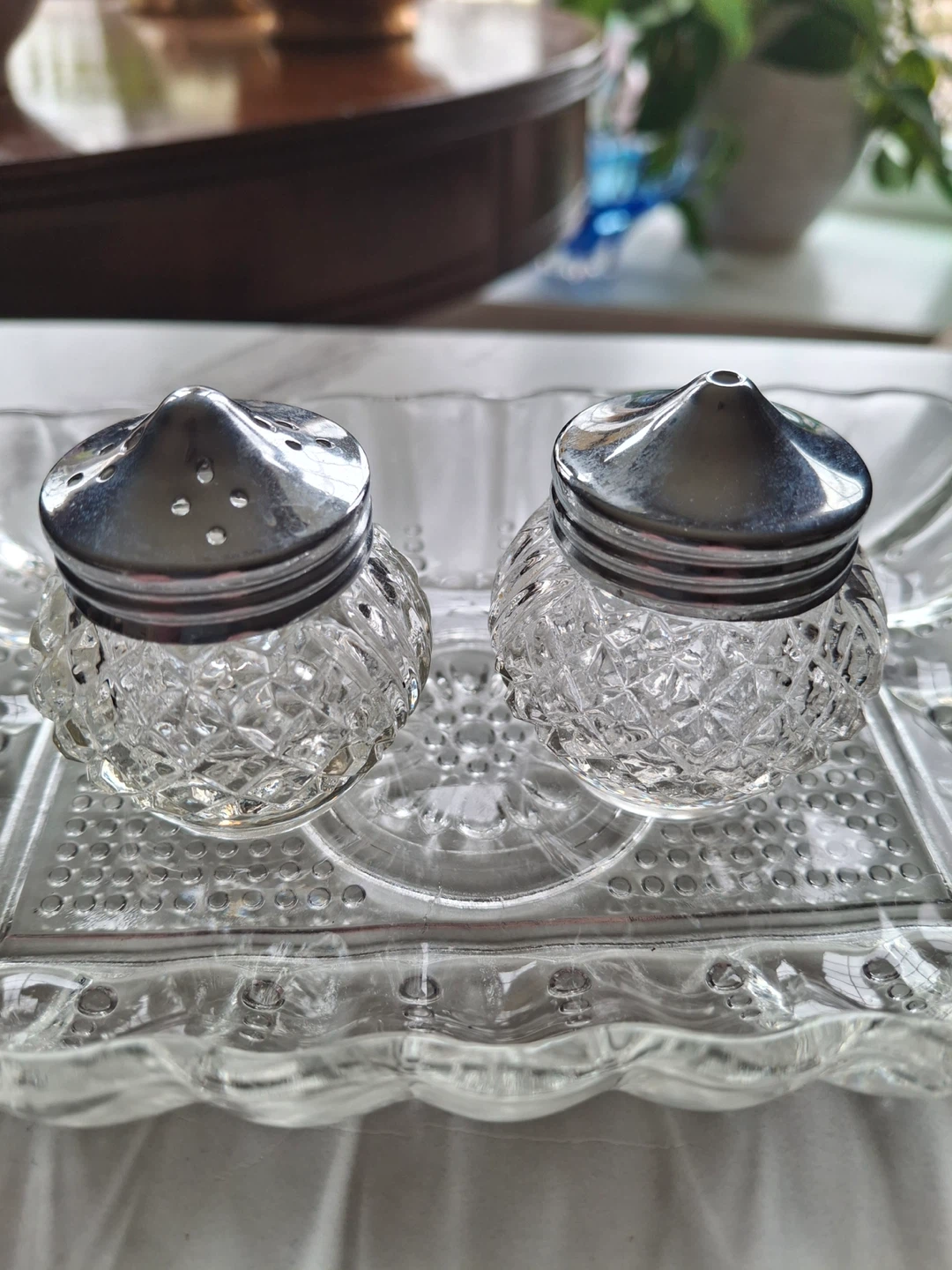 Small salt & pepper shakers on vintage glass tray