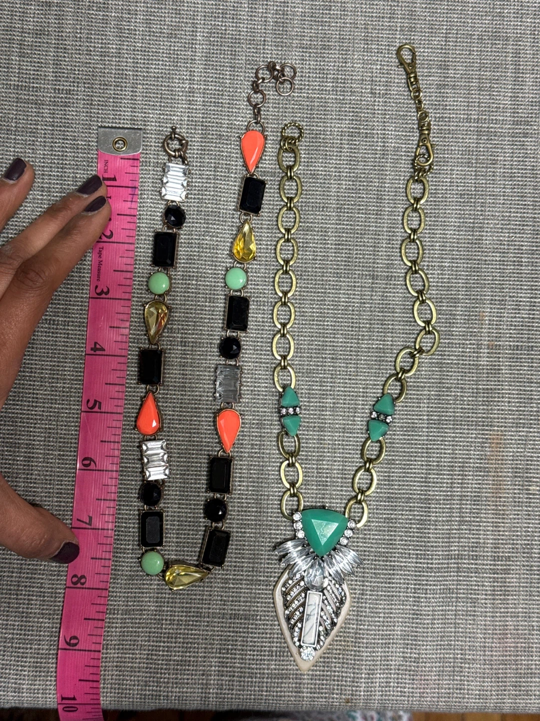 Two fashion necklaces, one with orange, green, and black beads