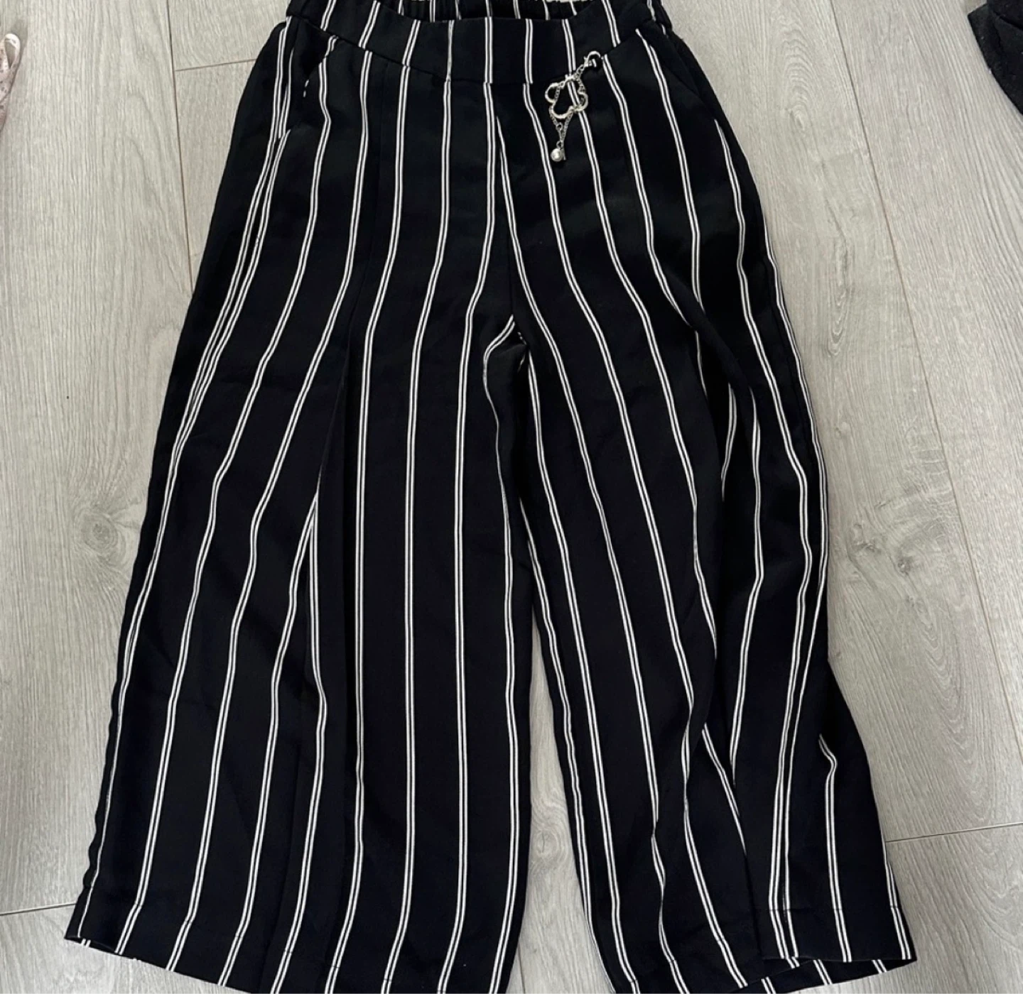 Black and white striped wide-leg pants with charm