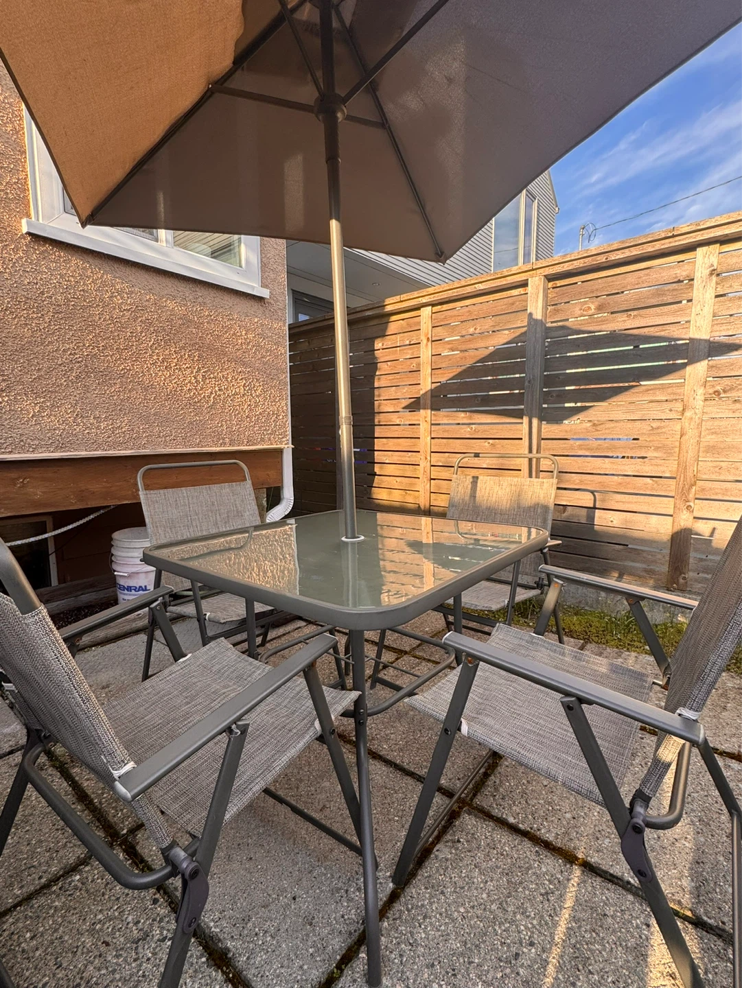 Glass patio table and chairs with umbrella