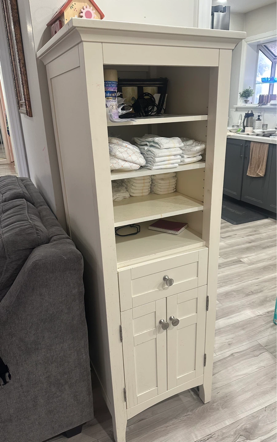 Cream coloured tall cabinet with drawer and doors